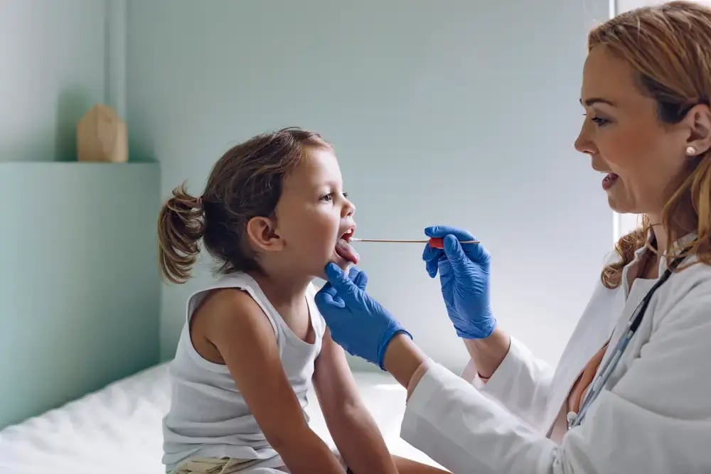 doctor swabs a child.